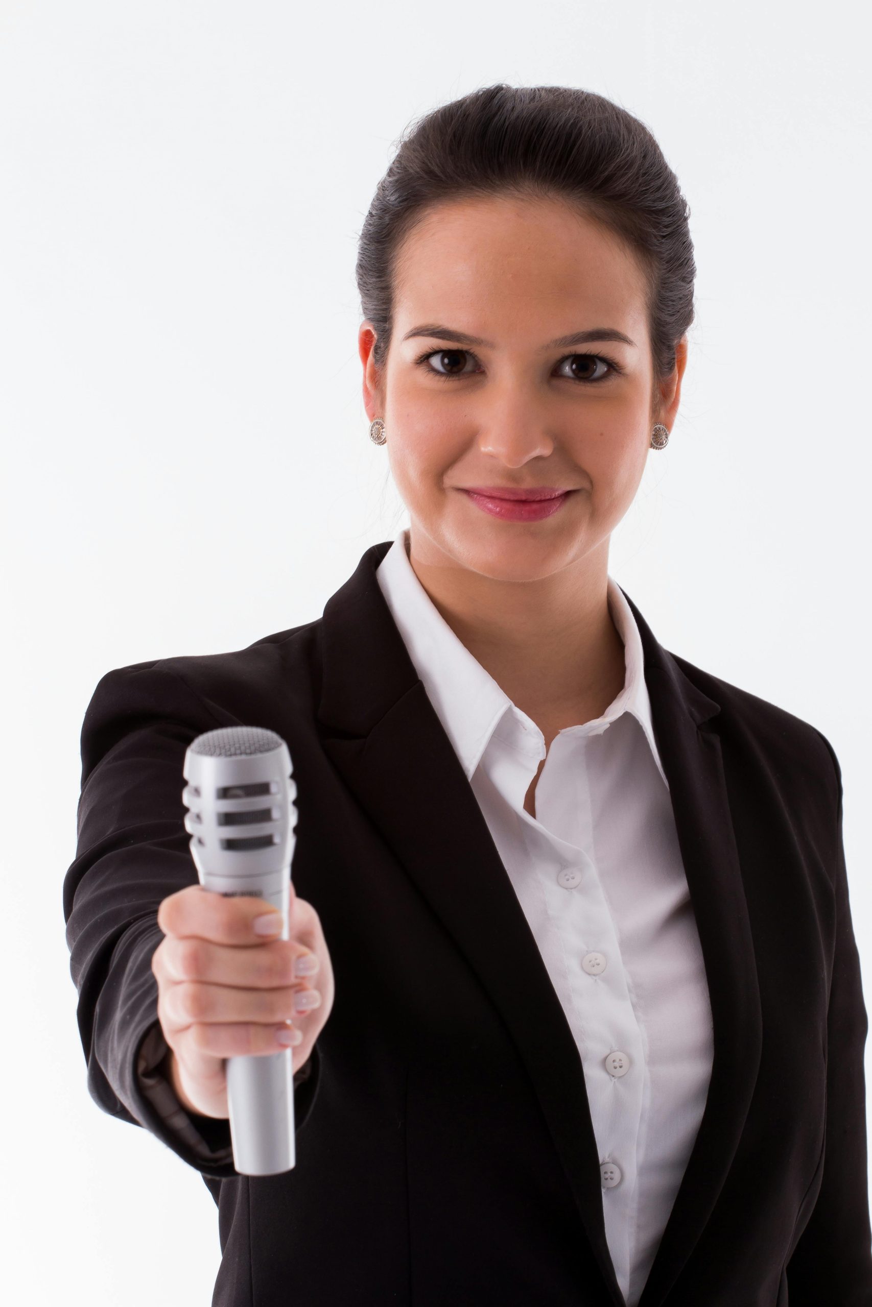 Confident woman in a black blazer holding microphone for presentation or interview.
